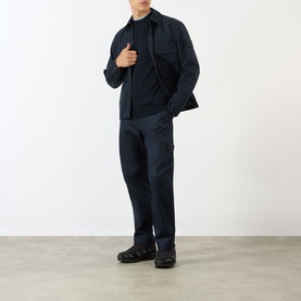 Model wearing Stone Island blue wool crew neck knit, styled with matching navy overshirt and trousers, and black trainers.
