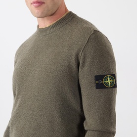 Model wearing Stone Island Verde Militare Melange wool crew neck jumper, featuring signature compass badge patch on sleeve.
