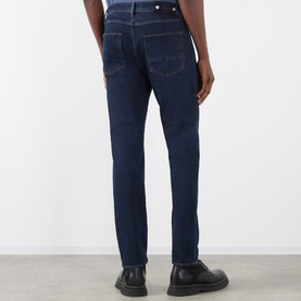 Model wearing Stone Island blue rinse slim-fit jeans, rear view, styled with black leather shoes.