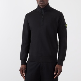 Model wearing Stone Island black quarter-zip sweatshirt with badge logo patch, styled with matching black joggers.