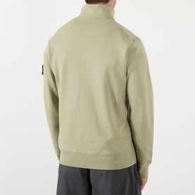 Model wearing Stone Island Compass Logo Half-Zip Fleece Sweatshirt in Laurel Green, back view, with grey trousers.