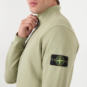 Model wearing Stone Island Compass Logo Half-Zip Fleece Sweatshirt in Laurel Green, close-up of funnel neck and sleeve logo badge.