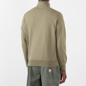 Model wearing Stone Island military green cotton quarter-zip sweatshirt, back view, styled with khaki trousers