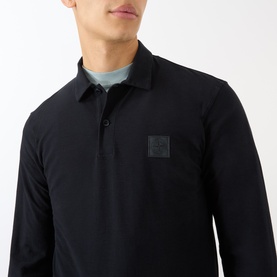 Model wearing Stone Island Compass Logo Long-Sleeved Polo Shirt in blue, with logo patch, polo collar, and button fastenings, styled with a grey