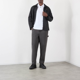 Model wearing Stone Island white polo with dark zip jacket, charcoal trousers and black shoes.