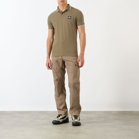 Model wearing Stone Island Compass Logo Tipped Polo Shirt in military green with cargo trousers and chunky trainers.