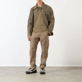Model wearing Stone Island Compass Logo Tipped Polo Shirt in military green, styled with matching jacket, cargo trousers and chunky trainers.