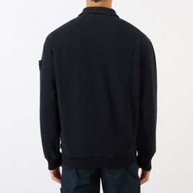 Model wearing a black zip-neck sweatshirt, back view, with Stone Island badge on left sleeve