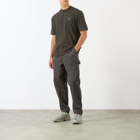 Model wearing Stone Island Compass Logo T-Shirt in coal grey with crew neck, paired with grey cargo trousers and white trainers.