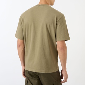 Model wearing Stone Island Compass Logo T-Shirt in military green, rear view, crew neck, short sleeves, styled with olive cargo trousers.