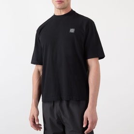 Model wearing Stone Island Compass Logo T-Shirt in black, round neck, short sleeves, small square logo patch at chest.