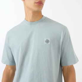 Model wearing Stone Island Compass Logo T-Shirt in ash grey cotton, featuring crew neck and signature compass logo patch at chest.