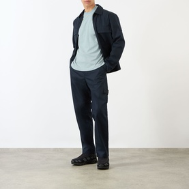 Model wearing Stone Island Compass Logo T-Shirt in ash grey, styled with navy cargo trousers and a dark zip-up jacket.
