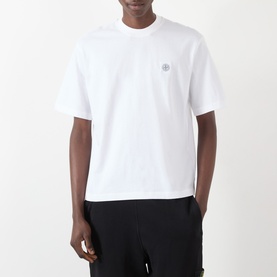 Model wearing Stone Island white cotton T-shirt with chest logo patch, styled with black trousers