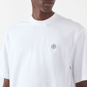 Model wearing Stone Island white cotton T-shirt, close-up showing chest badge logo patch detail