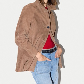 Model wearing Jigsaw light brown suede jacket, styled with red top and light wash jeans