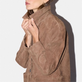 Model wearing Jigsaw light brown suede jacket, close-up showing collar and front snap fastening detail