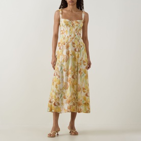Model wearing Bardot Adaline Floral Print Dress in yellow floral, sweetheart neckline, wide straps, flared midi skirt, styled with strappy sandals