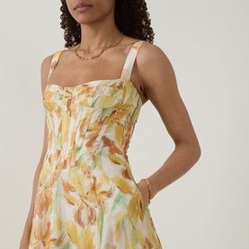 Model wearing Bardot Adaline Floral Print Dress in Yellow Floral, showing structured sweetheart bodice and wide straps; styled with gold chain