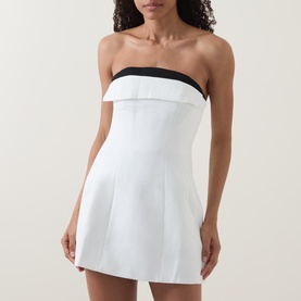 Model wearing Bardot mini dress in orchid white, strapless with contrast black trim neckline and flared skirt silhouette