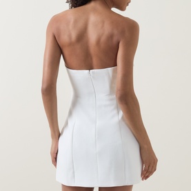 Model wearing Bardot orchid white strapless mini dress, shown from behind, featuring structured boned bodice and tailored fit.