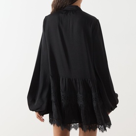 Model wearing Bardot Antonia Lace Trim Mini Dress in black, showing rear view with voluminous sleeves, lace inserts and flared mini skirt.