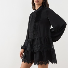 Model wearing Bardot Antonia Lace Trim Mini Dress in black, featuring pintuck detail, lace hem inserts, voluminous sleeves and mandarin collar.
