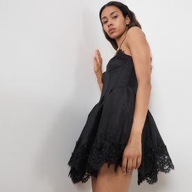 Model wearing Bardot black mini dress with lace hem trim, spaghetti straps, and fit-and-flare silhouette