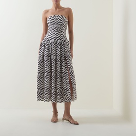 Model wearing Bardot Isalia Strapless Printed Dress in brown zebra print, midi length with box pleat skirt and leg split, styled with nude kitten