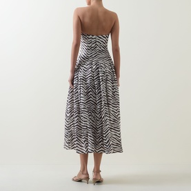 Model wearing Bardot Isalia Strapless Printed Dress in brown zebra print, midi length with full box pleat skirt, back view, styled with nude heeled