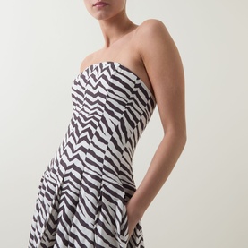 Model wearing Bardot Isalia Strapless Printed Dress in brown zebra print, with structured boned bodice and box pleat skirt visible.