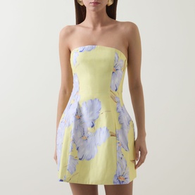 Model wearing yellow strapless mini dress with large blue floral print, fitted bodice and full skirt silhouette