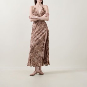 Model wearing Bardot Lizbeth Leopard Slip Dress in leopard print, V-neckline, halter straps, high side split, maxi length, styled with flat sandals