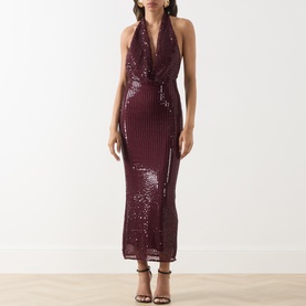 Model wearing Bardot deep plum sequin halterneck midi dress with wrap-style front, styled with strappy heeled sandals