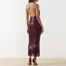 Model wearing Bardot Deep Plum sequin halterneck midi dress with open back, styled with strappy heels