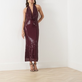Model wearing Bardot deep plum sequin halterneck midi dress, styled with black strappy heeled sandals