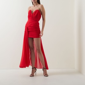 Model wearing Bardot Remalia Gathered Mini Dress in fire red, strapless sweetheart neckline, ruched bodice, sheer draped overlay, styled with strappy