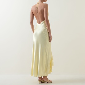 Model wearing Bardot canary yellow halterneck midi dress with open back and flared skirt, styled with nude heeled mules