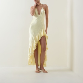 Model wearing Bardot canary yellow halterneck maxi dress with ruffle hem asymmetric skirt, styled with strappy flat sandals