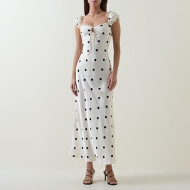 Model wearing Bardot Black Spot midi dress in white viscose with black polka dots, square neckline, cap sleeves and side split, styled with brown