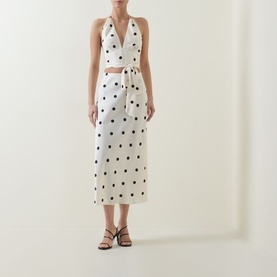 Model wearing Bardot Taryn Lace Detail Dress in canary yellow with black polka dots, halter neck, cut-out waist, midi length, styled with black