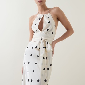 Model wearing Bardot Taryn Lace Detail Dress in canary yellow with black polka dots, halterneck keyhole neckline and tie waist detail.