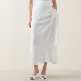Model wearing Bardot Solene Cut-Out Skirt in Orchid White with side cut-out, gathered tie detail and flared hem, styled with white heeled mules.