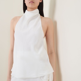 Model wearing Bardot Solene Draped Blouse in Orchid White with high cowl neckline, sleeveless design, styled with white shorts.