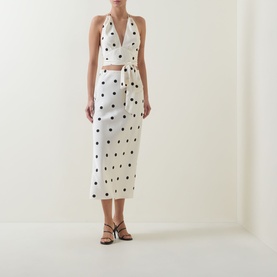 Model wearing Bardot Pheobe Polka Dot Slip Skirt in Black Spot with matching halter top, styled with black strappy heeled sandals.