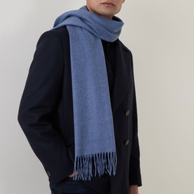 Model with Corneliani Cashmere Fringed Scarf in blue, herringbone weave with fringe ends, styled over dark navy overcoat