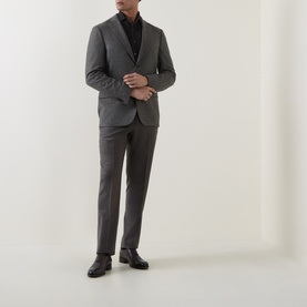 Model wearing Corneliani grey green wool jacket, styled with matching trousers, black turtleneck and black leather shoes.