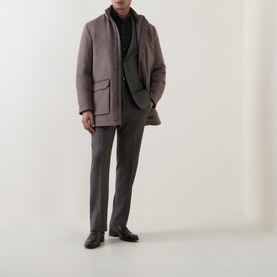 Model wearing Corneliani grey green wool jacket with patch pockets, styled with grey trousers and black derby shoes.