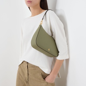 Model carrying Lauren Danni Medium Shoulder Bag in sage green leather with gold-tone hardware, worn as shoulder bag, styled with white top and khaki