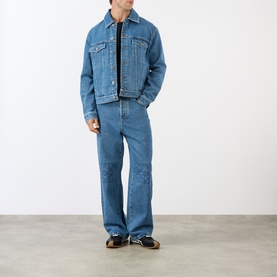Model wearing Loewe Anagram Logo Denim Jacket in jeans blue with matching denim jeans, styled with a black T-shirt and brown shoes.
